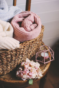 Close-up of pink flowers and textile in basket on table