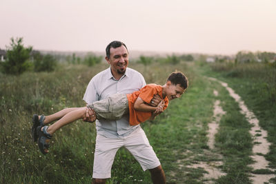 Happy fathers day. father with son are walking in the field.