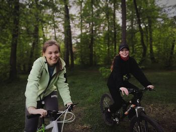 Portrait of smiling woman riding bicycle in forest