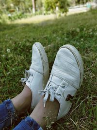 Low section of person wearing shoes on field