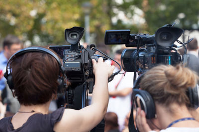 Rear view of women operating cameras during event