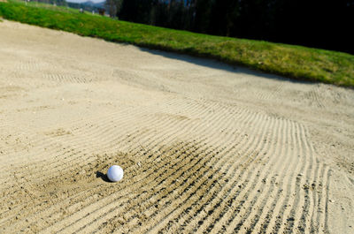 Golf ball on sand during sunny day