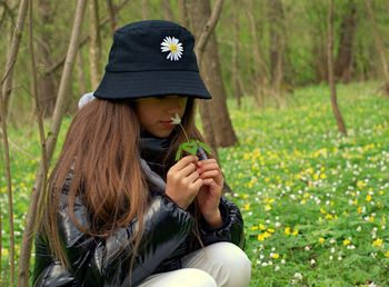 Low section of girl holding flowering plant