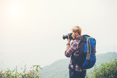 Close-up of young man photographing in forest