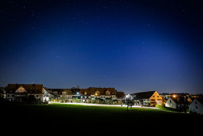 Illuminated buildings against sky at night