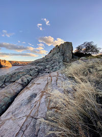 Rock formation on land against sky during sunset