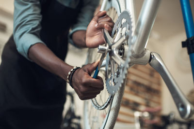 Midsection of man repairing bicycle
