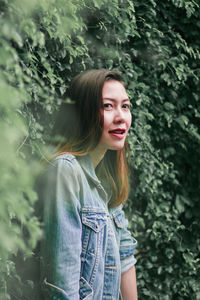 Portrait of smiling woman standing in forest