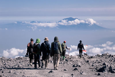 Rear view of people on mountain road against sky