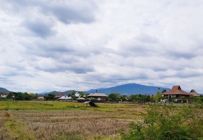 Houses on field against sky