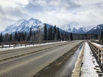 Road amidst snowcapped mountains against sky