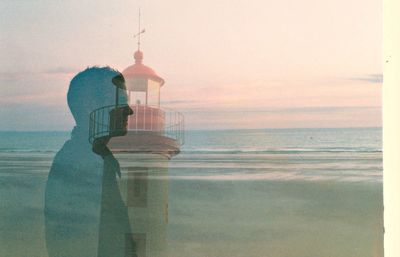 Man on beach against sky during sunset