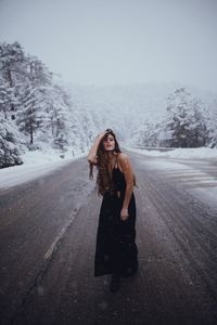 Portrait of young woman standing in snow