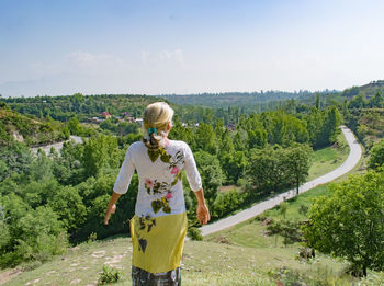 Portrait of woman standing on field against sky