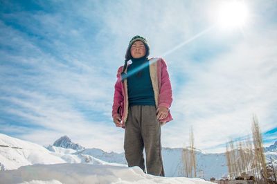 Man standing on snowcapped mountain against sky