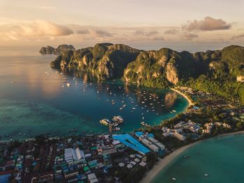 High angle view of sea by rock formation against sky during sunset