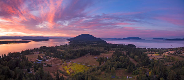 Panoramic view of town by sea against sky during sunset