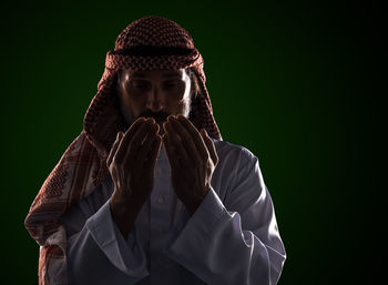 Portrait of woman wearing mask against black background