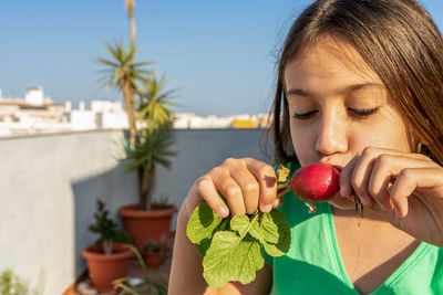 Close-up of girl smelling fruit