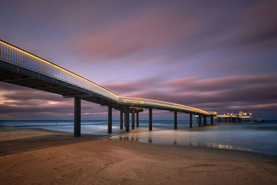 Pier over sea against sky at sunset