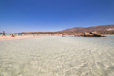 Scenic view of beach against clear blue sky