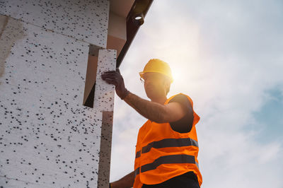 Low angle view of man standing against sky