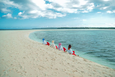 People at beach against sky
