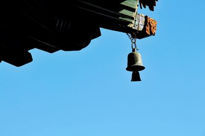 Low angle view of hanging against clear blue sky