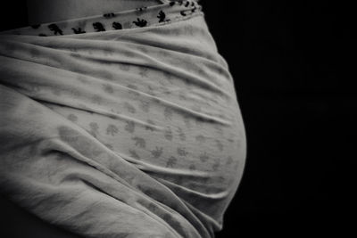 Close-up of man holding hat against black background