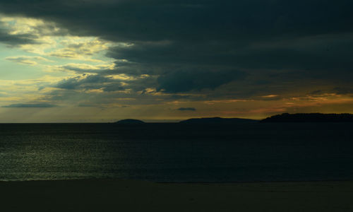 Scenic view of sea against dramatic sky during sunset