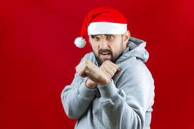 Portrait of man wearing hat against red background