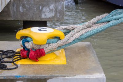 Close-up of rope tied up on cleat at harbor