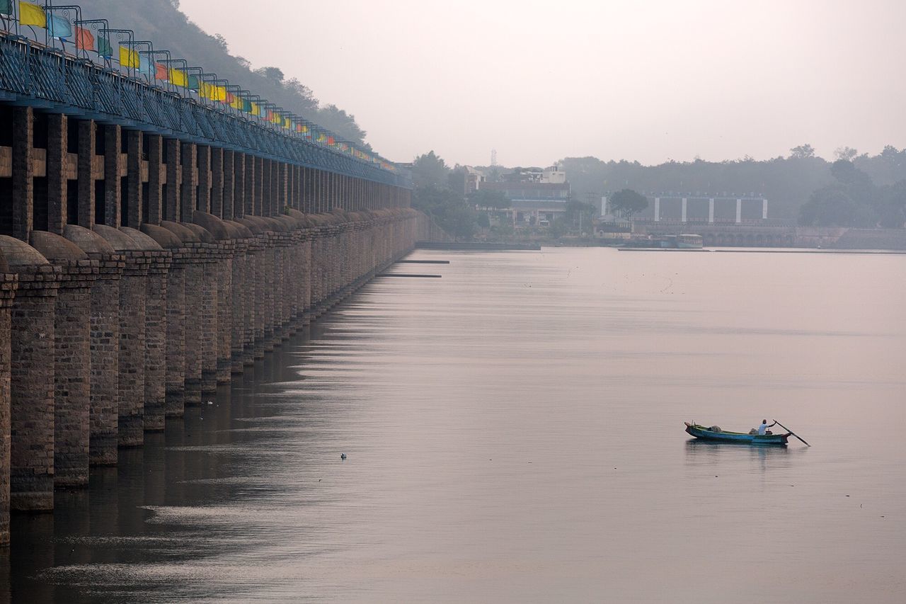 architecture, built structure, building exterior, transportation, water, city, waterfront, mode of transport, river, bridge - man made structure, nautical vessel, connection, sky, canal, boat, travel, clear sky, incidental people, travel destinations, building