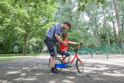 Full length of father and son with bicycle at park