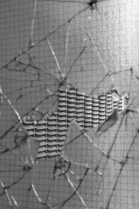 Close-up of broken window against wall 