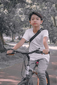 Full length of boy looking at bicycle