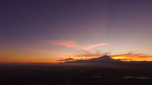 Scenic view of silhouette mountains against orange sky