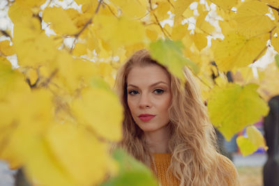 Portrait of young woman with yellow leaves
