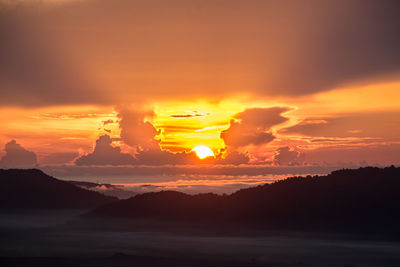 Scenic view of silhouette mountains against romantic sky at sunset