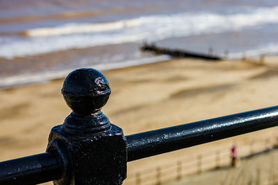 Close-up of metal railing on beach
