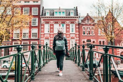 Woman walking on footbridge in city