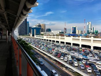 High angle view of cars at parking lot in city against sky