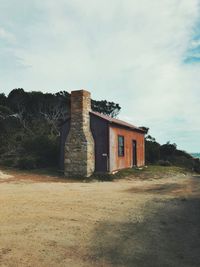 Old house on field against sky