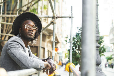 Portrait of young man looking away in city