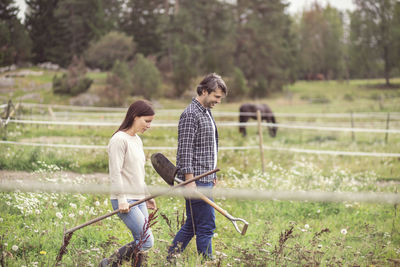 Side view of mid adult couple walking in organic farm