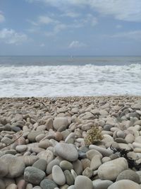 Stones on beach against sky