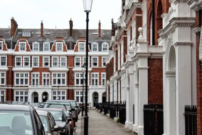 Cars on city street against sky