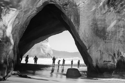 People on rock by sea