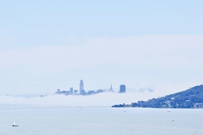 View of city by sea against sky