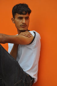 Young man against orange background